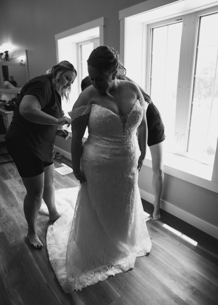 Bride getting into her dress at Bluebird Hill Iowa wedding venue