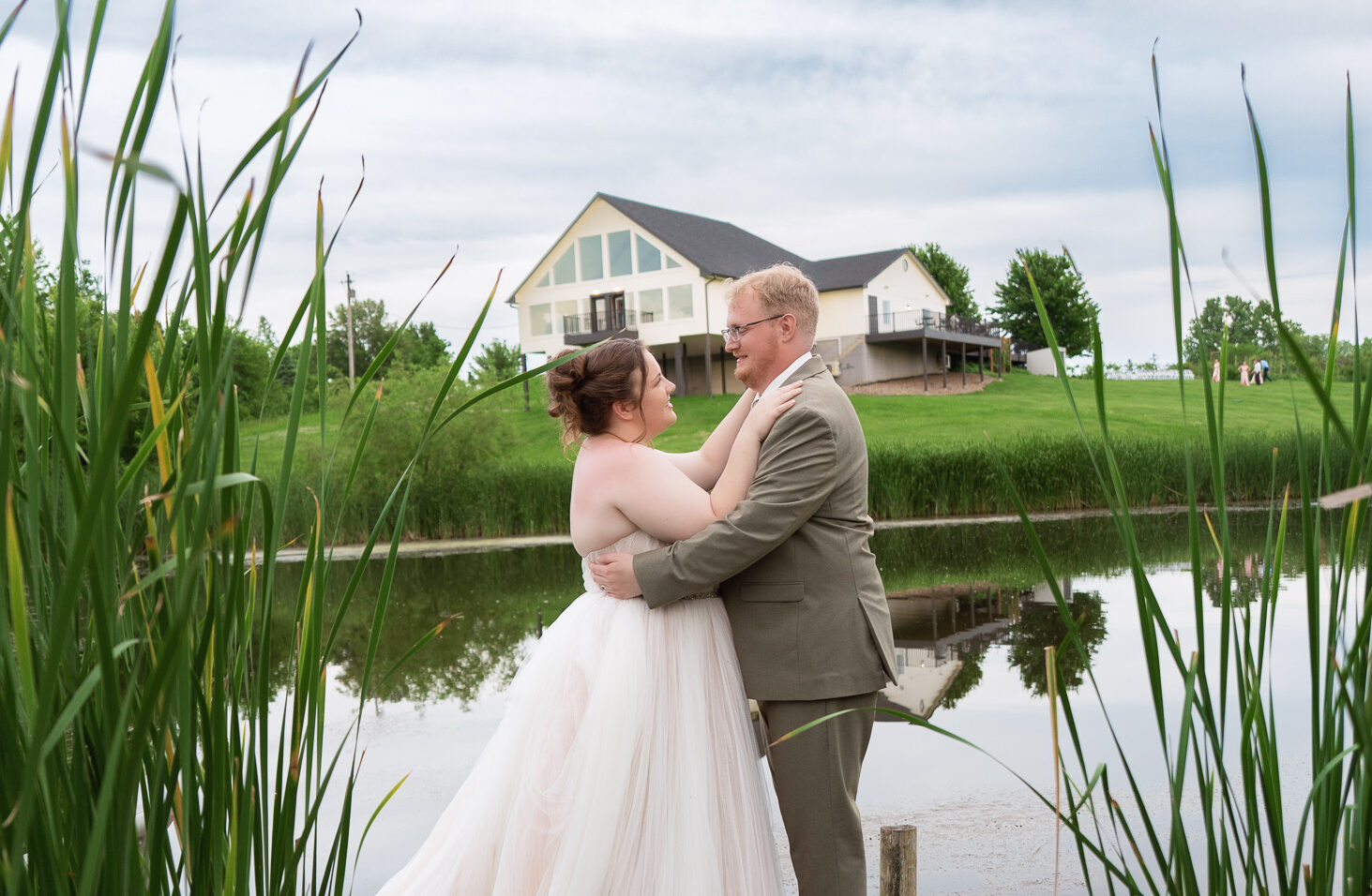 Iowa Bride and groom in front of the pond on their wedding day at The Vineyard at St. Charles